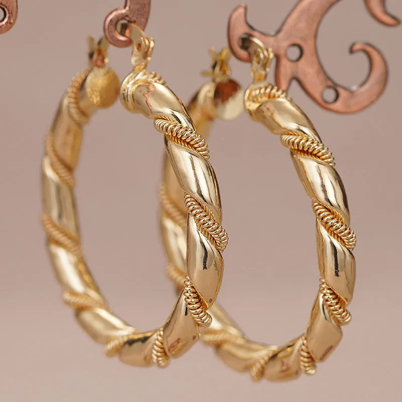 Golden geometric earrings with ring and line design elements on copper