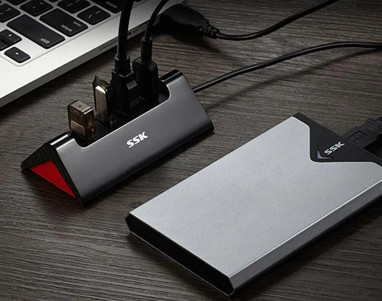 Black USB expansion dock with four ports, compact rectangular design, and a Micro USB power cable.