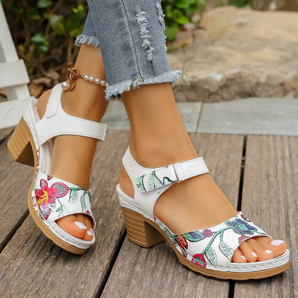 White women's high heel sandals with a Velcro strap buckle on a rubber sole.