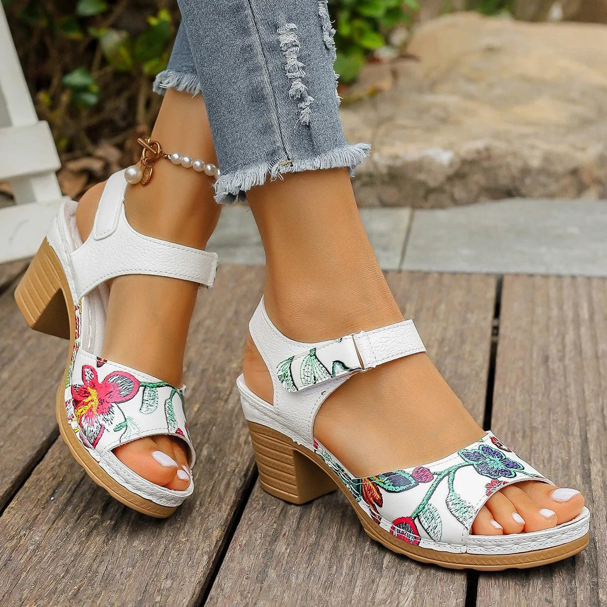 White women's high heel sandals with a Velcro strap buckle on a rubber sole.