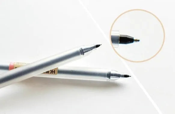 Set of twelve black Muji gel pens with 0.5mm fine tips, shown with caps off.