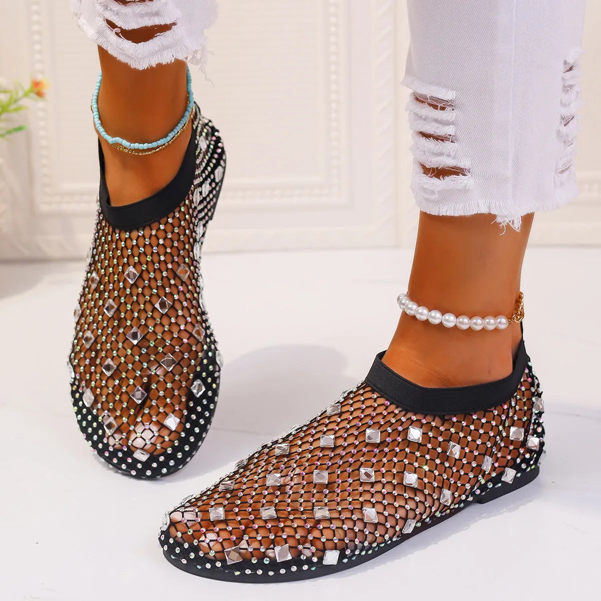 Women's flat sandals with mesh upper, colourful rhinestone detail, and a round toe.