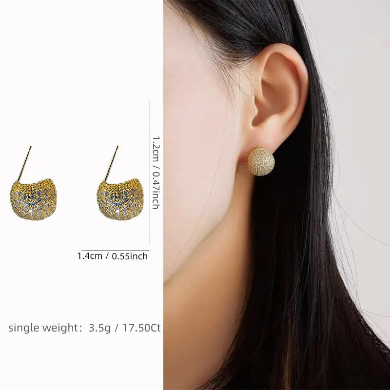 Drop-shaped geometric sphere earrings with full diamond design and little golden beans details in gold colour