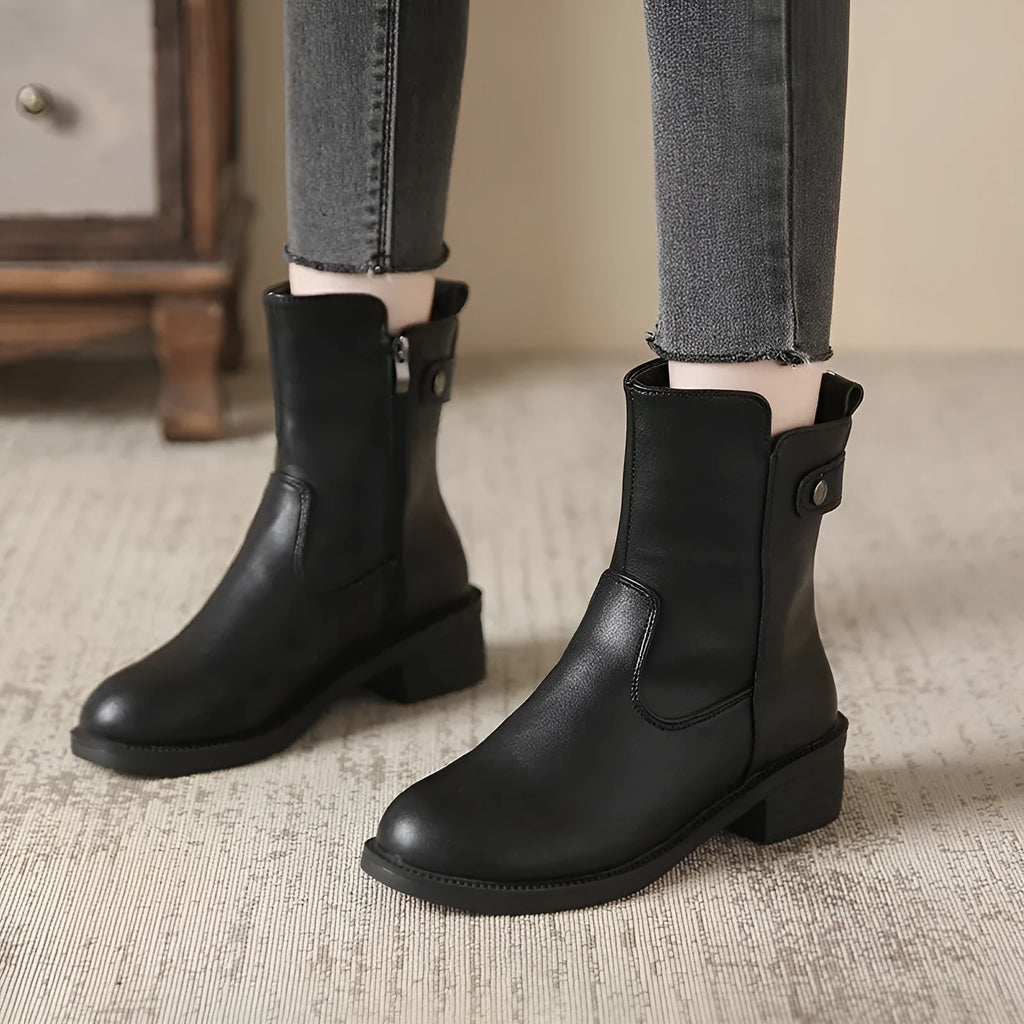 Black women's low heel ankle boots with side zip and round toe on a rubber sole.