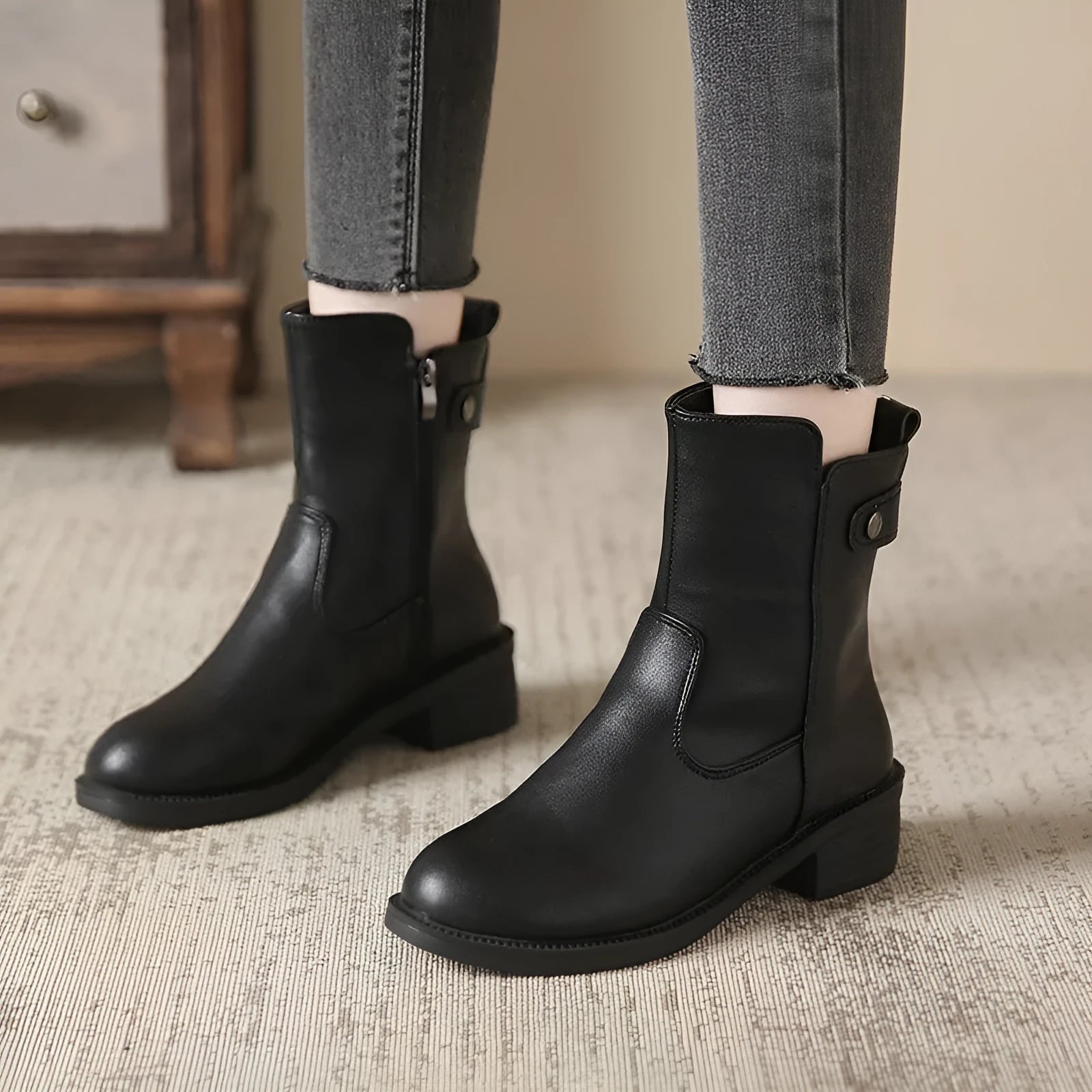 Black women's low heel ankle boots with side zip and round toe on a rubber sole.