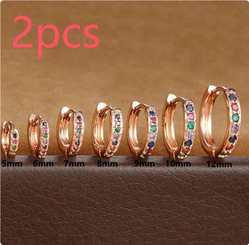 Gold, rose gold, and silver circle stud earrings with a perforated geometric design in various sizes.