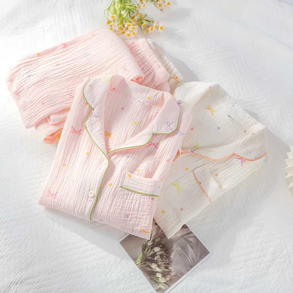Women's long-sleeved cotton pyjama set in pink, showing top and trousers laid flat