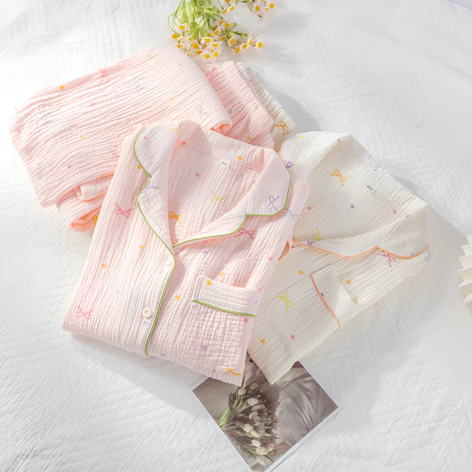 Women's long-sleeved cotton pyjama set in pink, showing top and trousers laid flat
