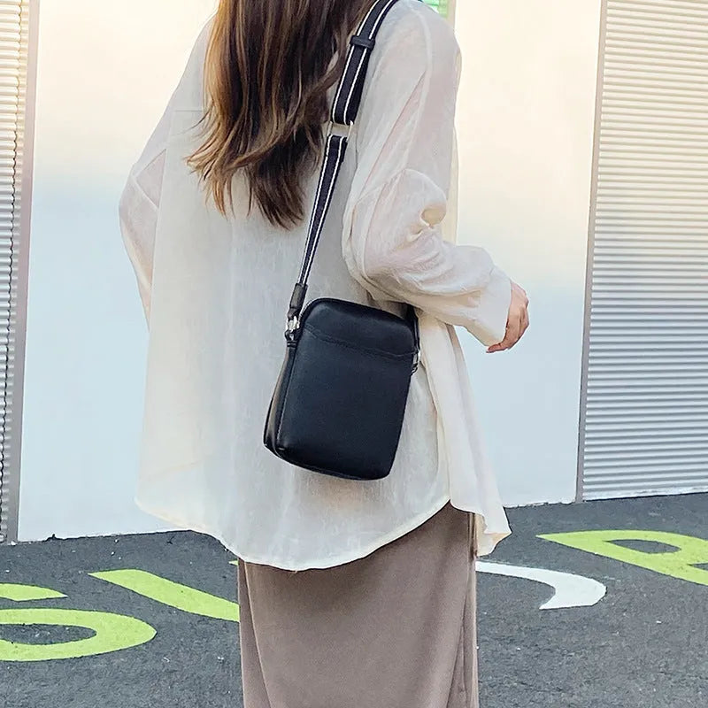 Black PU mobile phone bag with crossbody strap showing shoulder carry option