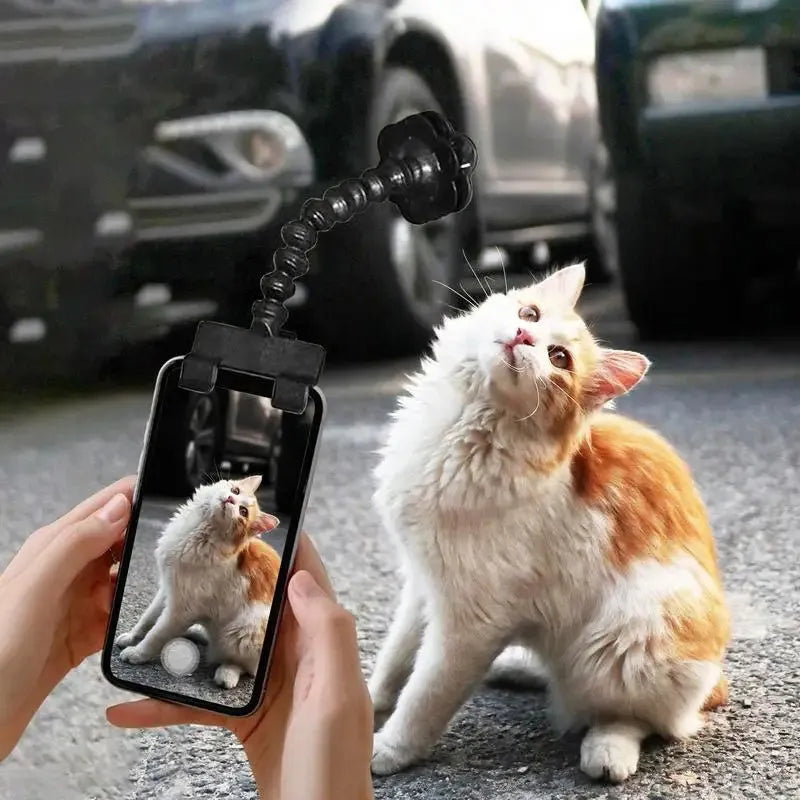 Black pet photography clip with rotating treat holder attached to mobile phone