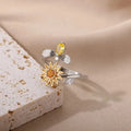 Gold and platinum coloured adjustable geometric decompression ring with rotatable element on a white background.