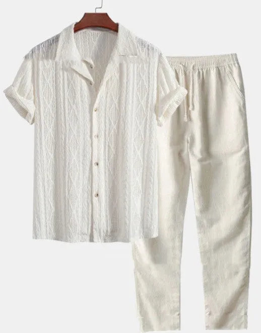 Man wearing a loose blue short sleeve shirt and matching trousers from a milk silk polyester summer suit set.