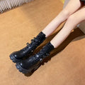 A pair of black mid-calf women's boots with metal buckle details and a side zipper on a white background.