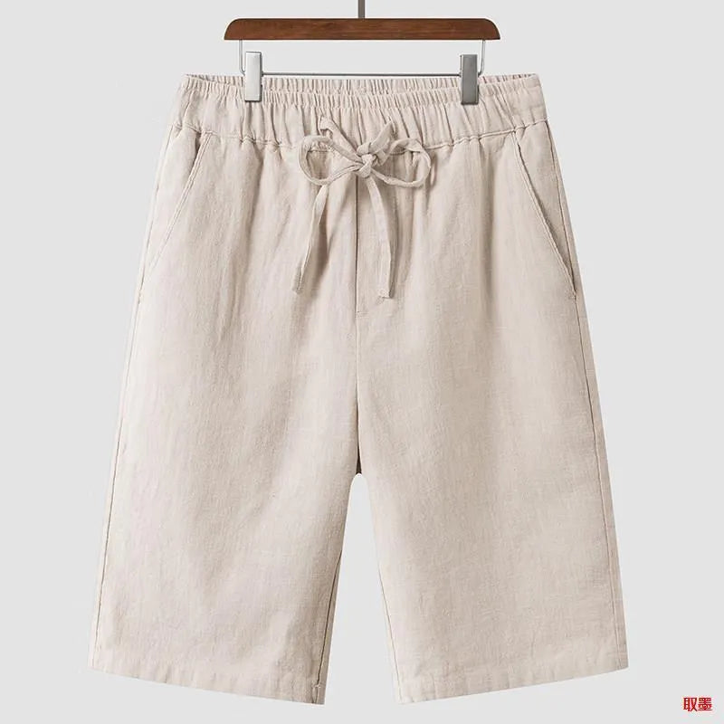 Man wearing beige linen casual shorts with a loose, cropped fit and elasticated mid waist.