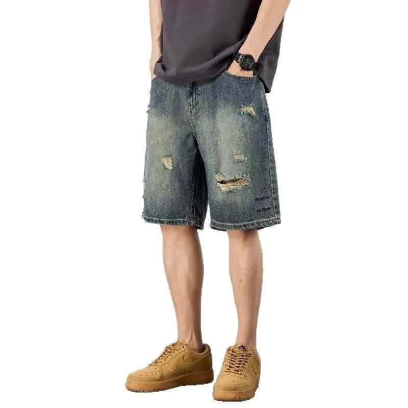 Men's blue denim shorts with retro loose hole distressing and a straight-leg cut.