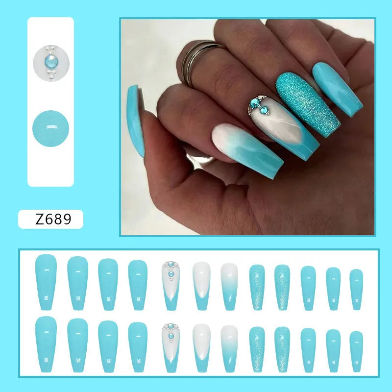 Long ballet false nails with smart blue diamond accents on solid colour background