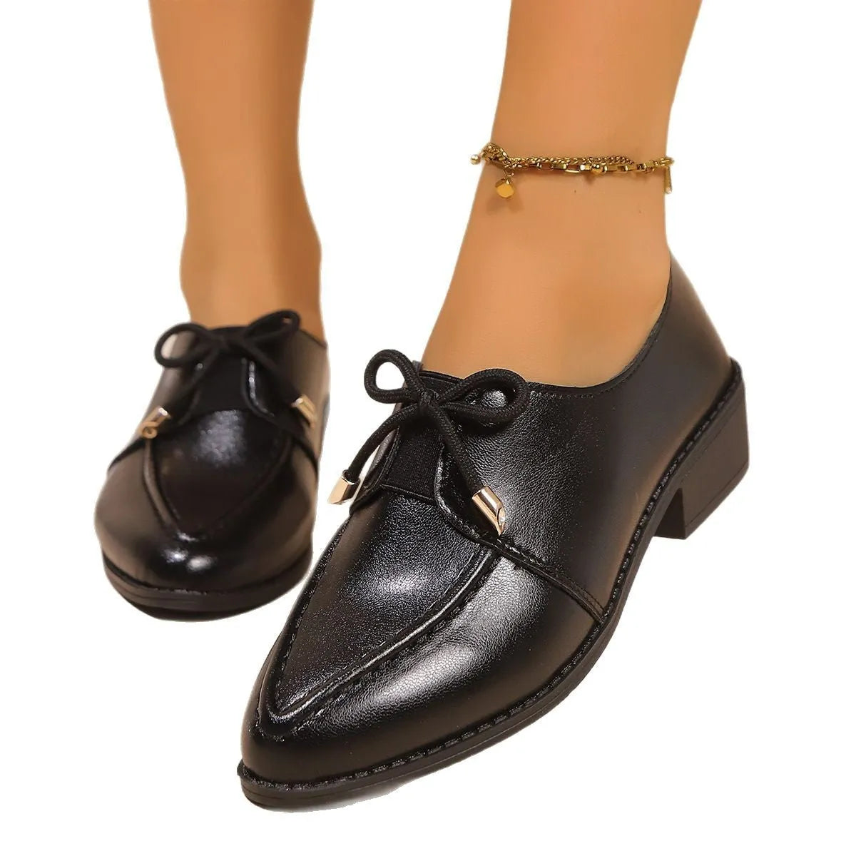 Women's brown PU leather slip-on shoe with a large bow on the pointed toe.