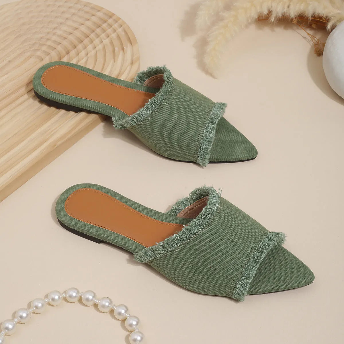 Women's flat denim slippers with a tassel detail, shown in apricot colour.