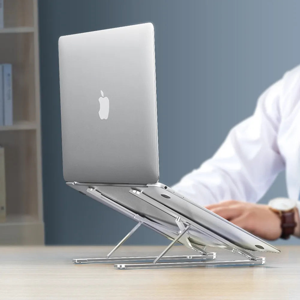 Silver foldable aluminium laptop stand holding a MacBook at an adjustable angle.