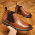 Men's formal black leather pointed-toe boots with a square heel on a white background