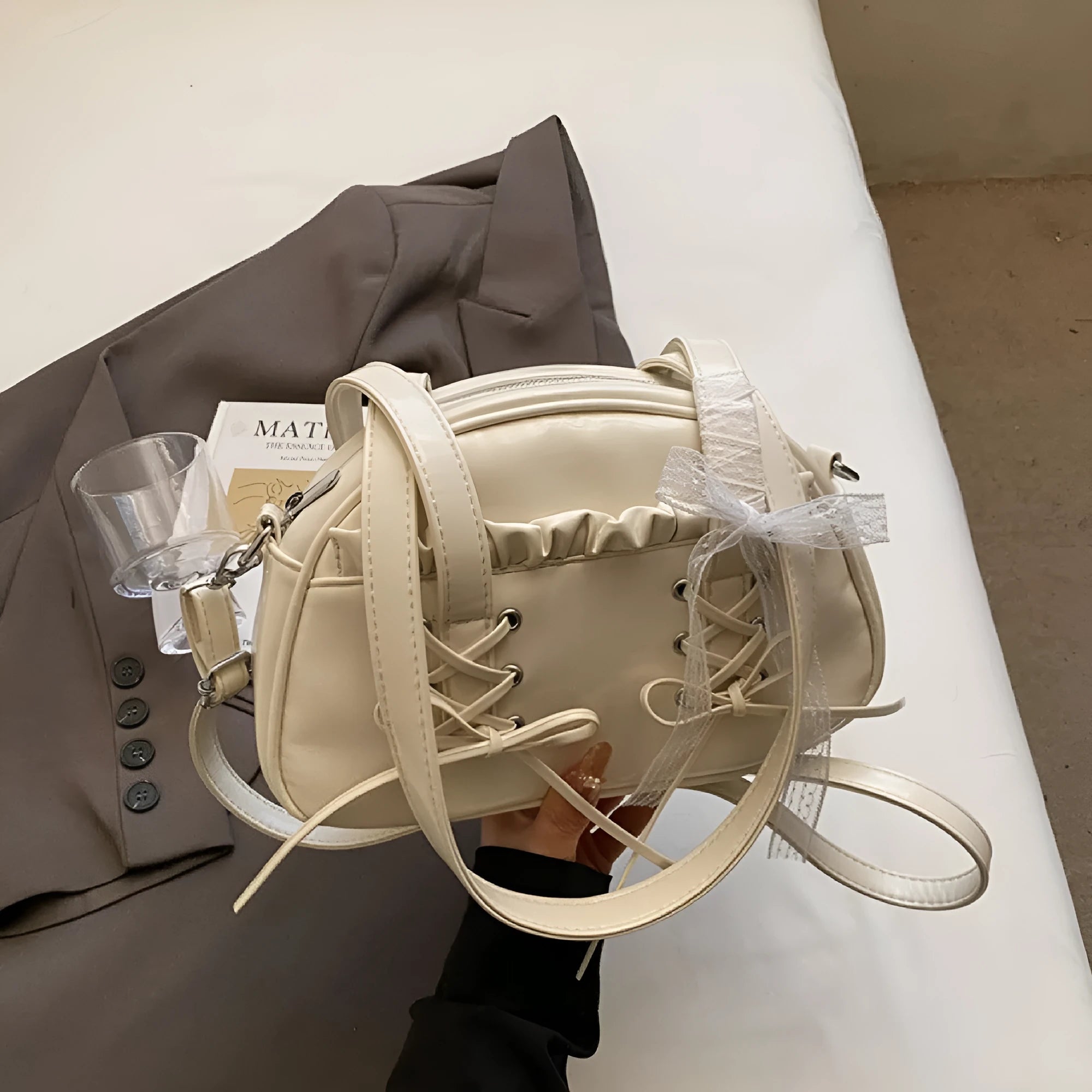Women's casual shoulder bag in PU leather with a white bandage bow design on the front.