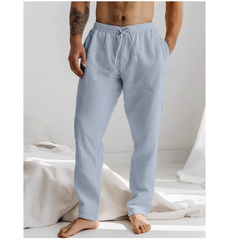 Man wearing light grey cotton-linen summer trousers with an elastic waist and straight leg fit.