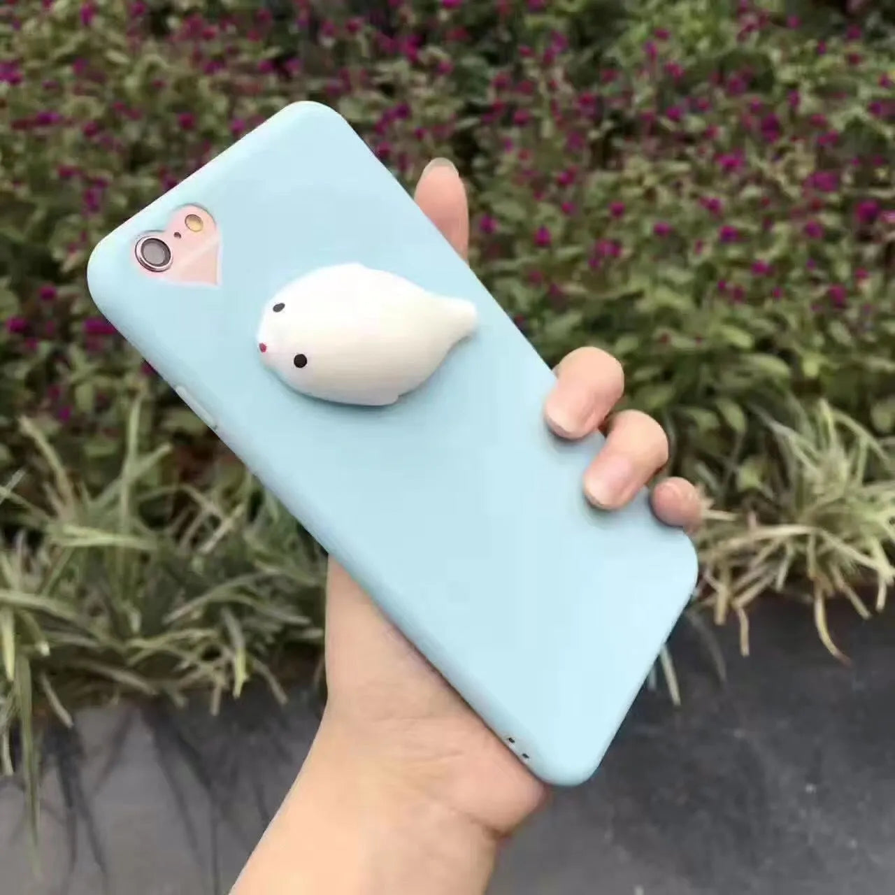 Soft silicone iPhone case with a raised 3D cartoon cat design, shown in pink.