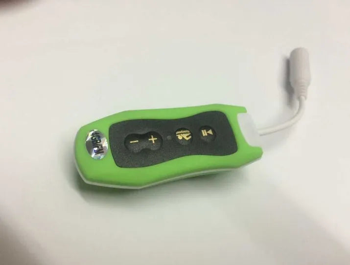 Compact black Bluetooth MP3 headset with USB cable, shown next to scale for size.