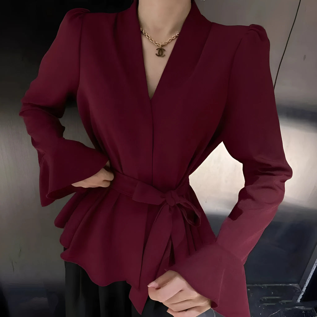 A woman's French-style black shirt with an irregular collar, long bell sleeves, and a tied front closure.