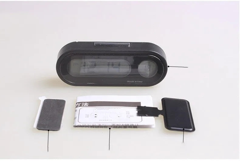 Black car dashboard clock thermometer with luminous LED display showing time and temperature