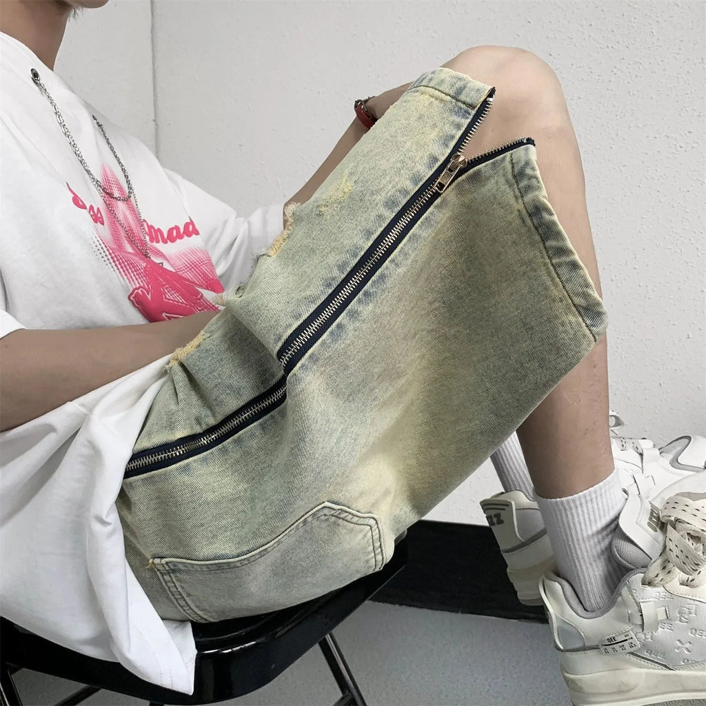 Men's blue denim shorts with a yellow mud distressed finish, rips, loose five-point fit, and button cardigan closure.