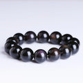 Polished icy obsidian crystal Pi Xiu bracelet with geometric beads on a white background.
