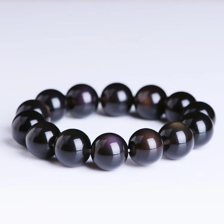 Polished icy obsidian crystal Pi Xiu bracelet with geometric beads on a white background.