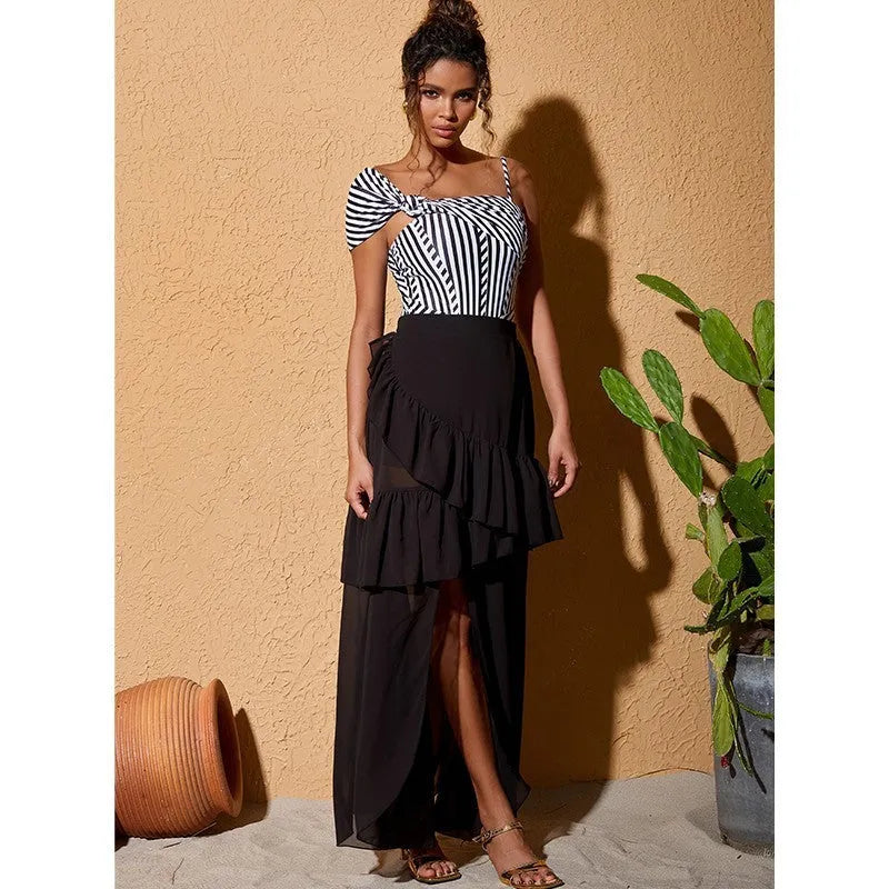 Women's black and white striped one-piece swimsuit with a ruffled skirt.