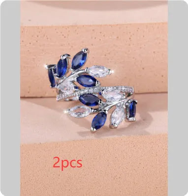 Adjustable copper leaf-shaped ring with zircon gemstone colour options on a white background.