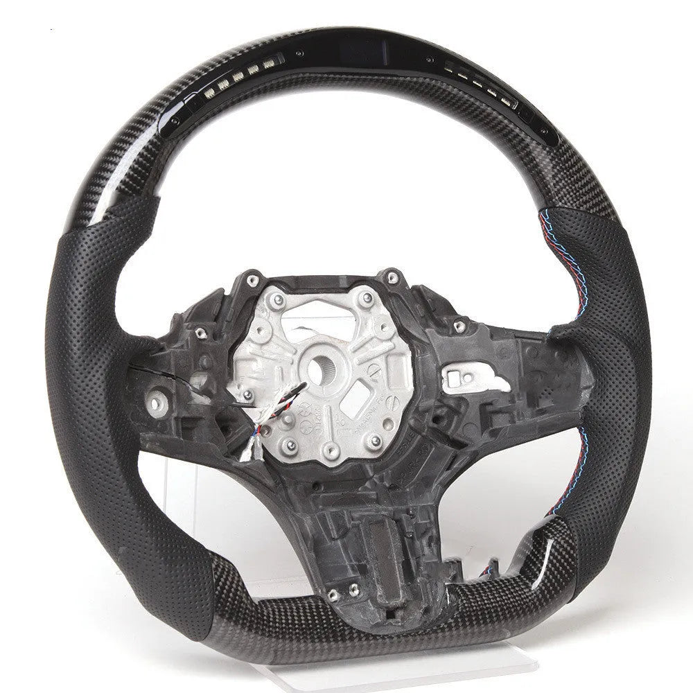 Black carbon fibre BMW sports steering wheel with integrated LED multifunctional display.
