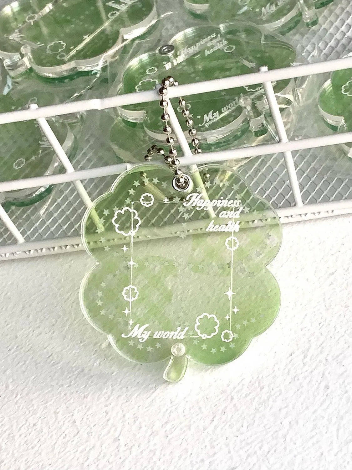 Blue four-leaf clover acrylic charm on a keychain ring.