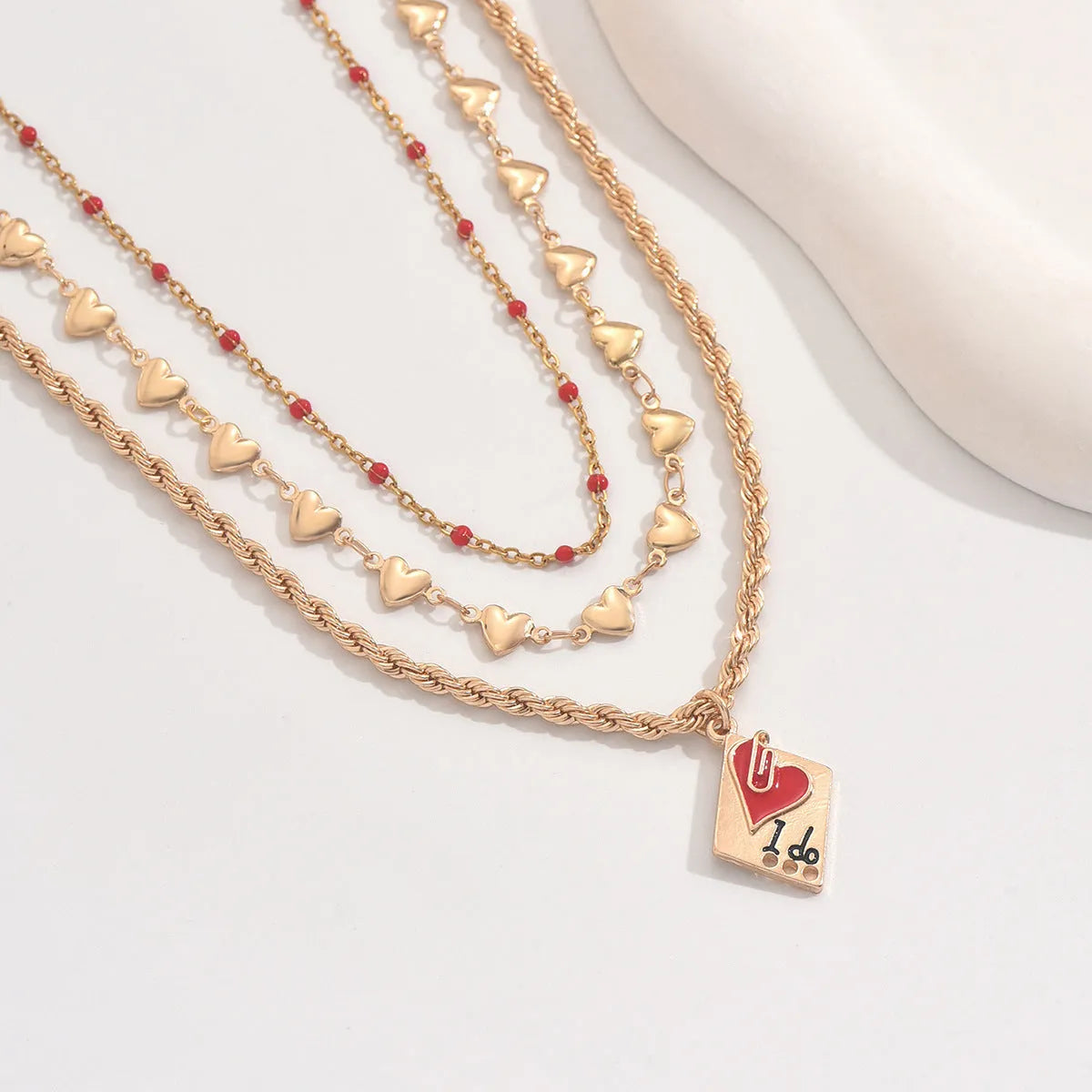 Adjustable three-layer zinc alloy clavicle chain necklace with a geometric heart pendant.