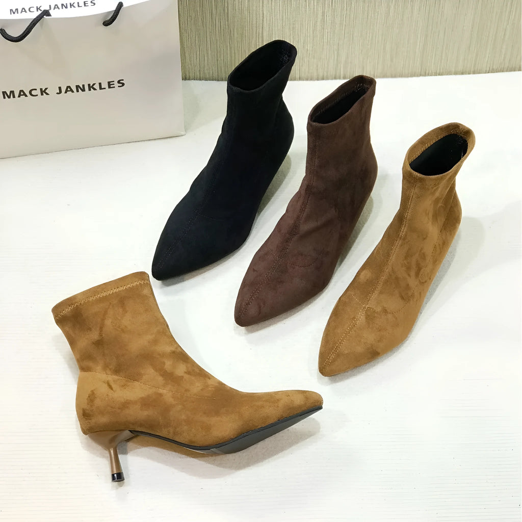Black pointed toe ankle boots with high stiletto heel and mid-calf shaft showing microfiber texture
