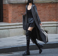 Long grey knitted women's cardigan with hood, modelled as a loose-fit trench coat.