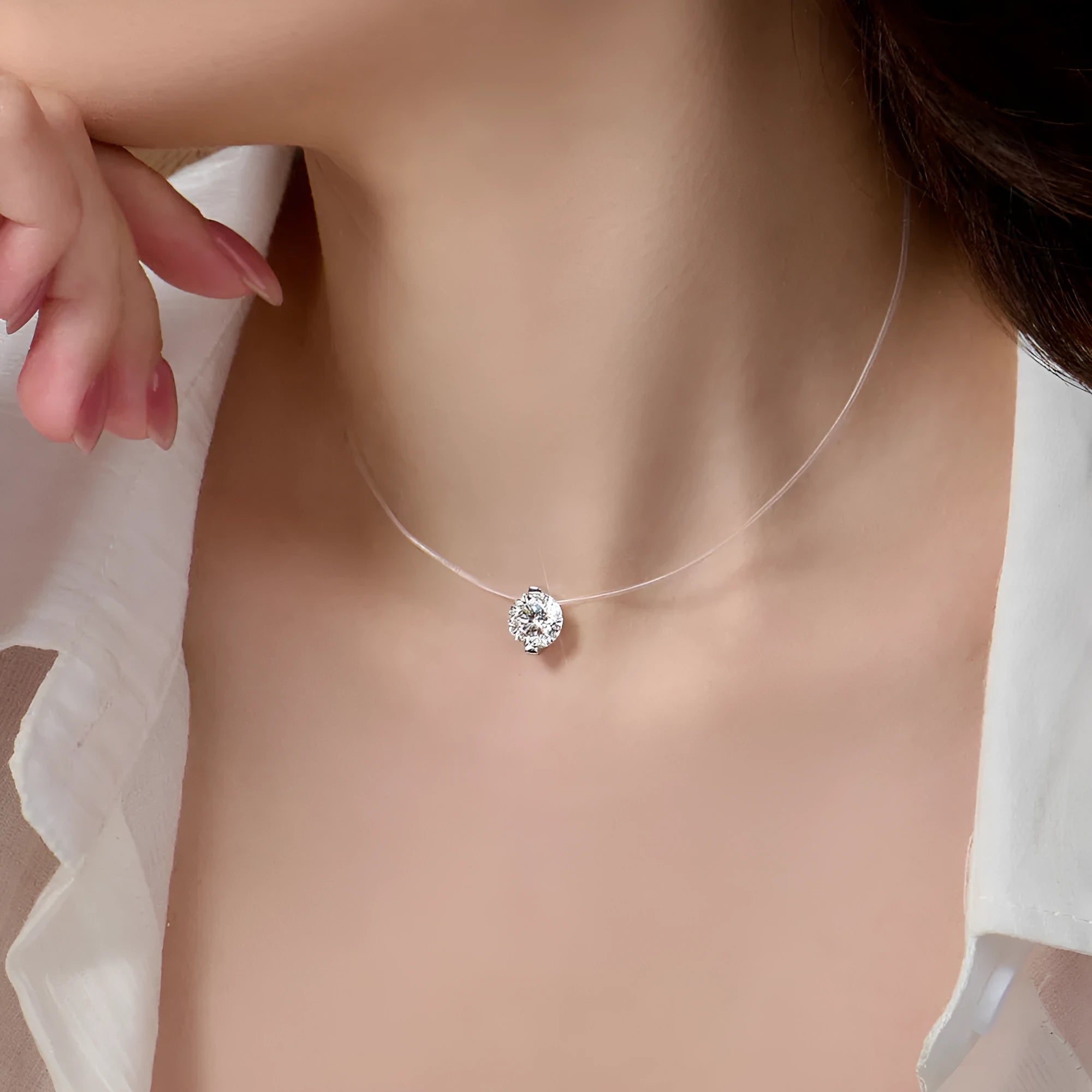 Women's sterling silver plum blossom necklace with a blue green moissanite stone on an invisible fishing line chain.