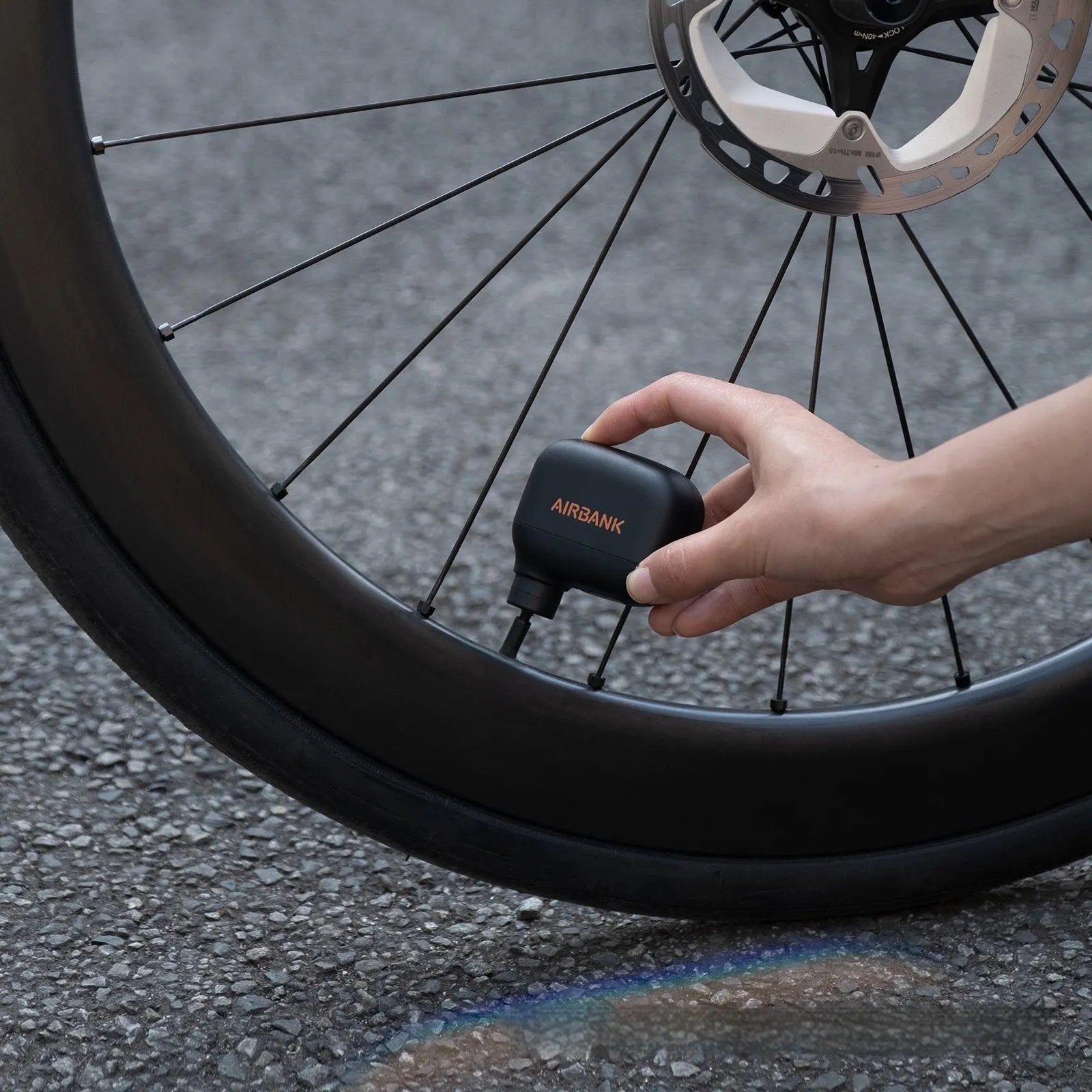 Black AS100 mini electric bicycle pump with USB charging cable and waterproof storage bag