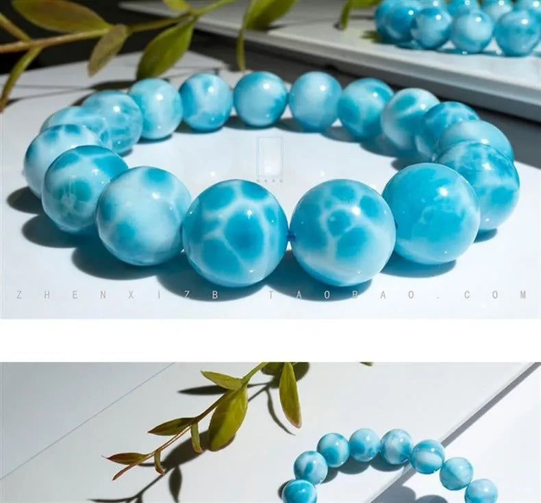 Blue handcrafted bodhi bracelet with sea-pattern crystal stones and pearl accents on a neutral background.