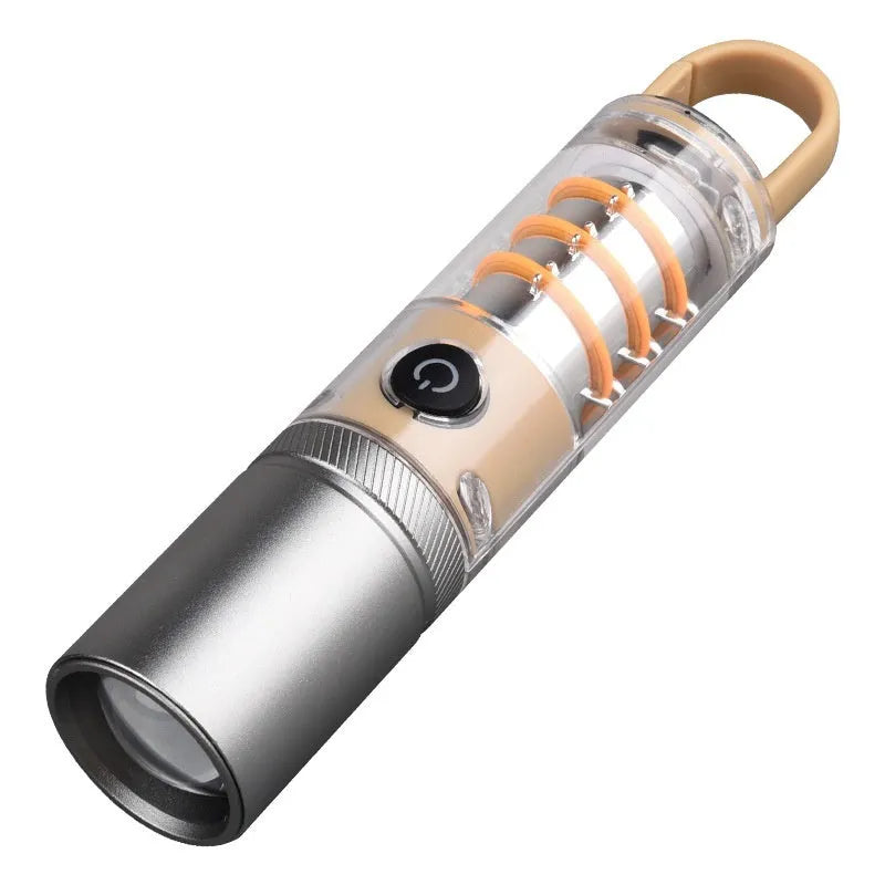 Orange and beige coloured LED torch with keychain loop, showing dual-light lens and USB port.
