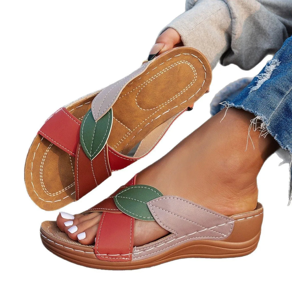 Women's black cross-strap peep-toe slippers with a thick sole, shown from the side.