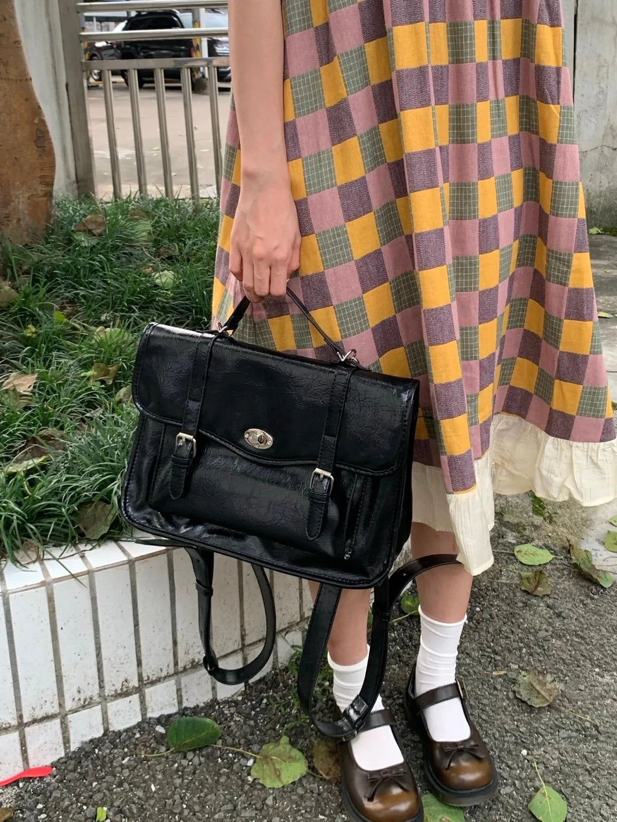 Black college style messenger bag for women made from oil wax leather-look PU material.