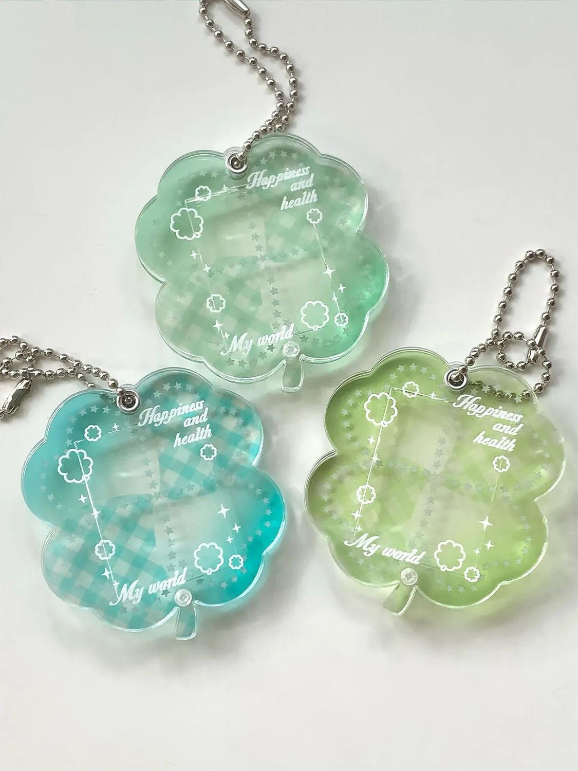 Blue four-leaf clover acrylic charm on a keychain ring.
