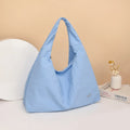 Soft black nylon women's underarm bag with heart shape and adjustable shoulder strap.