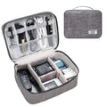 Black travel cable organiser bag open, showing mesh pockets, elastic loops, and removable padded dividers.