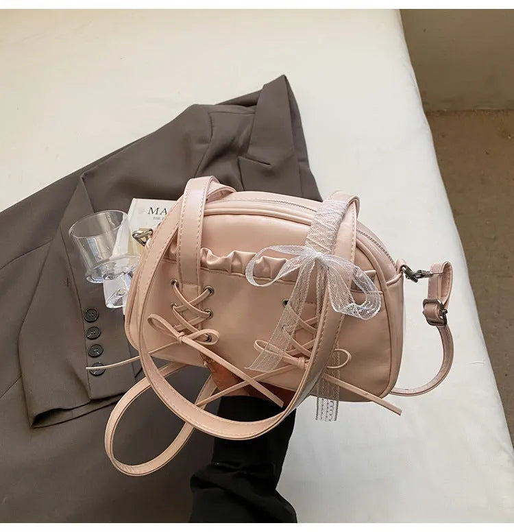 Women's casual shoulder bag in PU leather with a white bandage bow design on the front.